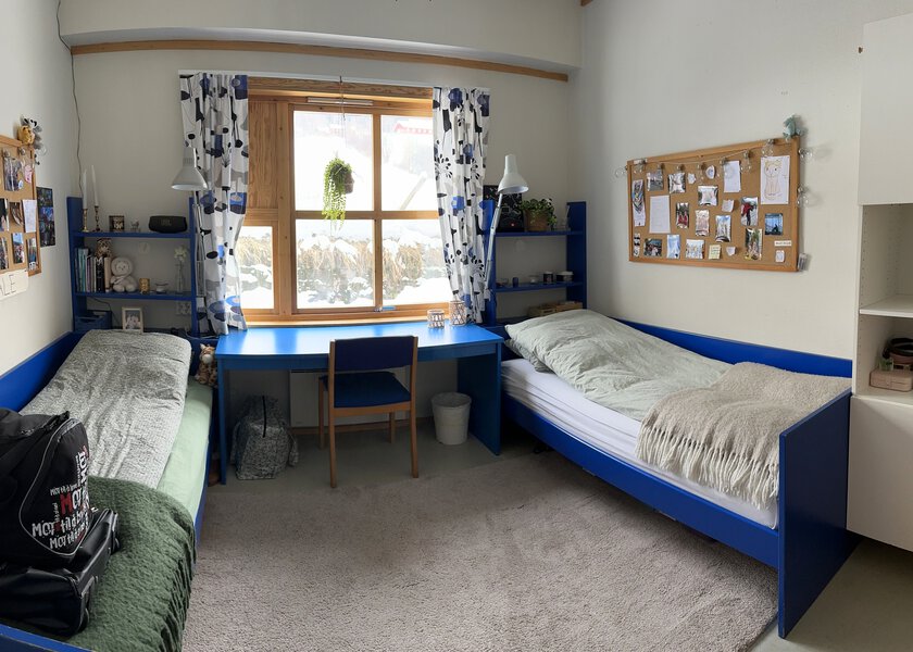 Rom med lyse vegger, to senger, pult og skap - Klikk for stort bilde